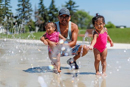 MIKE DEAL / FREE PRESS
Joannes Mendivil and his two daughters, Pia, 2, and Paula, 1, take advantage of the cool water at the Maples Spray Pad Monday afternoon.
Reporter: Tiago Resko
260713 - Monday, July 13, 2026.