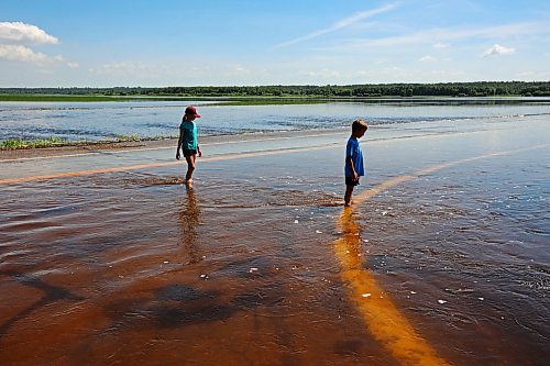 13072026
Siblings Emily and Brooks Zamrykut wade in the flood waters of the Assiniboine River pouring over Grand Valley Road near the Trans Canada Highway on a scorching hot Monday afternoon.
(Tim Smith/The Brandon Sun)