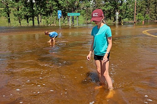 13072026
Siblings Brooks and Emily Zamrykut wade in the flood waters of the Assiniboine River pouring over Grand Valley Road near the Trans Canada Highway on a scorching hot Monday afternoon.
(Tim Smith/The Brandon Sun)