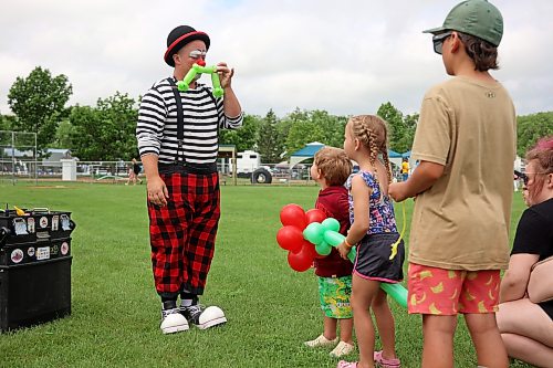Sleepy the Clown hams it up while making a balloon dinosaur for a child during Thursday's fair. (Tim Smith/The Brandon Sun)