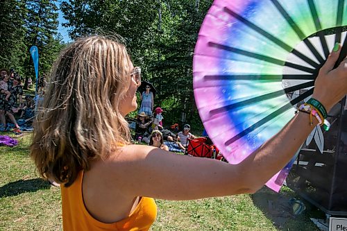 BROOK JONES/FREE PRESS
Folk Fest goer Ayla Prandzioch, 35, who is from Winnipeg, tries to keep cool with a hand fan while watching Yagódy perfrom on the Snowberry Field Stage on an extremely hot day at the 51st edition of the Winnipeg Folk Festival at Birds Hill Provincial Park in Manitoba on Sunday, July 12, 2026.