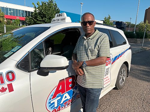 ABC Taxi president Abraham Takie stands in front of one of his cabs on Eighth Street in downtown Brandon on Friday. (Abiola Odutola/The Brandon Sun)