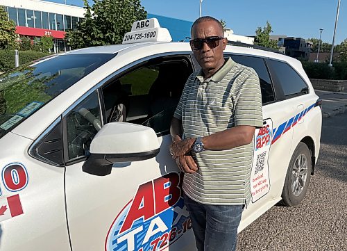 ABC Taxi president Abraham Takie stands in front of one of his cabs on Eighth Street in downtown Brandon on Friday. (Abiola Odutola/The Brandon Sun)