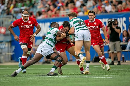 BROOK JONES/FREE PRESS
Team Canada player Noah Flesch (No. 11) runs with the ball while Team Zimbabwe Brandon Mudzekenyedzi (No. 13) and Zimbabwe teammate Matt McNab (No. 14) tackle him during first half action at Princess Auto Stadium on Saturday.