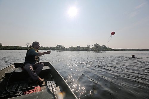 Austin Los of AAE Tech Services throws a marker that shows the location of a diver out on Shoal Lake. The diver dove up to 14 feet to service bubblers on the lakebed. (Connor McDowell/The Brandon Sun)