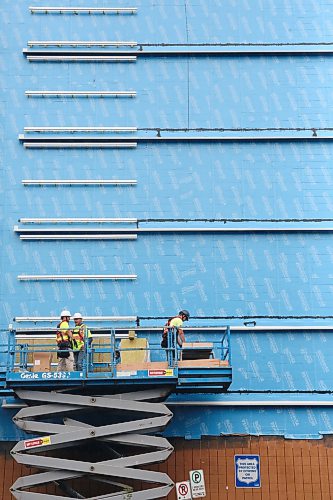 A three-man construction crew with PCL Construction work from the top of a lift on the south side of the former Lawson Lodge seniors apartment complex along Princess Avenue. The apartment building is attached to the former Prairie Oasis building at 261 Eight Street. (Matt Goerzen/The Brandon Sun)