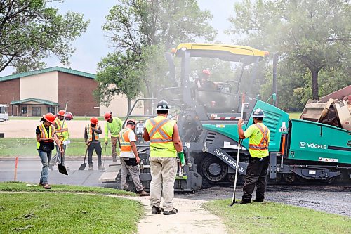 Road crews work behind paving machine being fed hot asphalt by a dump truck along the right lane of westbound Richmond Avenue on Tuesday afternoon. (Matt Goerzen/The Brandon Sun)