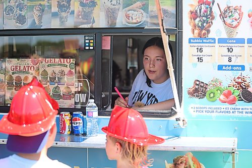 Veronika Plis, who helps operate the Happy Clover food truck, takes customers' orders during the 2026 Souris Peacock Days & Fair on July 11. (Abiola Odutola/The Brandon Sun)