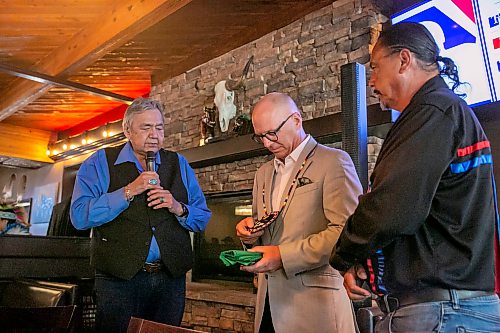 BROOK JONES/FREE PRESS
Members of the Indigenous Taxi Safety Committee and representatives from Duffy's Taxi and Unicity Taxi attend a breaking bread dinner with Winnipeg mayor Scott Gillingham at the Pony Corral on Nairn Avenue in Winnipeg, Man., Thursday, July 23, 2026. The event was held as a way to celebrate reconciliation and the taxi safety partnerships. Pictured: Winnipeg Mayor Scott Gillingham (middle) looks at a hand-beaded medallion he was presented with by Eric Robinson (left) who is chairman of the taxi safety committee and Elder Carol Stone (right).