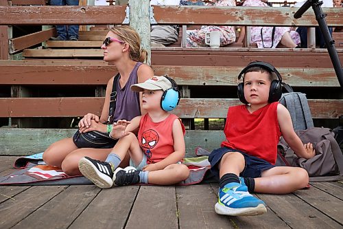 23072026
Karla MacTavish and her sons Cole and Logan watch the Pioneer Power Parade, where historic tractors, combines and other farm machinery parade through the grandstand, at the opening day of the 2026 Manitoba Thresherman’s Reunion and Stampede on Thursday afternoon. 
(Tim Smith/The Brandon Sun)