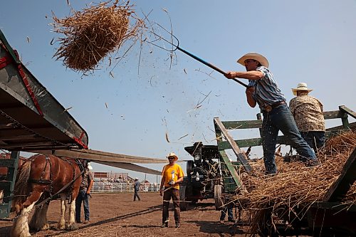 23072026
Competitors pitchfork sheaves of grain onto a thresher during the threshing competition in the arena at the opening day of the 2026 Manitoba Thresherman’s Reunion and Stampede on Thursday afternoon.
(Tim Smith/The Brandon Sun)