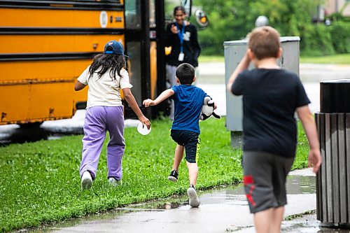 MIKAELA MACKENZIE / FREE PRESS
Kids run through the rain to a bus for an afternoon field trip at the Inner City Youth Alive vacation bible school day camp on Thursday, July 16, 2026.
For Zoe story.
Free Press 2026