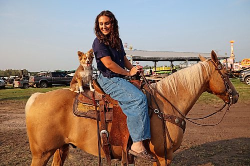 Grace Macza of High River, Alta., sits atop her horse Gus with her toy Australian shepherd Oda Mae prior to the opening go-round of the 2026 Manitoba Thresherman’s Reunion & Stampede rodeo on Thursday evening. (Tim Smith/The Brandon Sun)