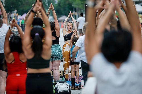 JOHN WOODS / FREE PRESS
Jessica from Rogue Vinyasa Yoga leads a session outside on a closed Corydon Avenue Sunday, July 26, 2026. The city is closing Corydon on multiple Sundays throughout the summer.

reporter: standup