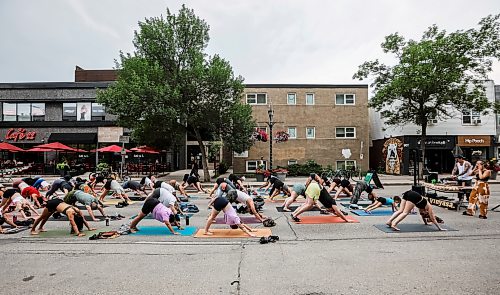 JOHN WOODS / FREE PRESS
Jessica from Rogue Vinyasa Yoga leads a session outside on a closed Corydon Avenue Sunday, July 26, 2026. The city is closing Corydon on multiple Sundays throughout the summer.
reporter: standup