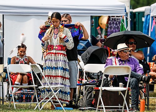 JOHN WOODS / FREE PRESS
Lena Spence assists Honey Shingoose as she prepares to participate in the grand entrance of the powwow at Anishinaabe Days Sunday, July 26, 2026.
reporter: standup