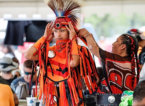 JOHN WOODS / FREE PRESS
Irene Bear assists her son Jayden as they prepare to participate in the grand entrance of the powwow at Anishinaabe Days Sunday, July 26, 2026.
reporter: standup