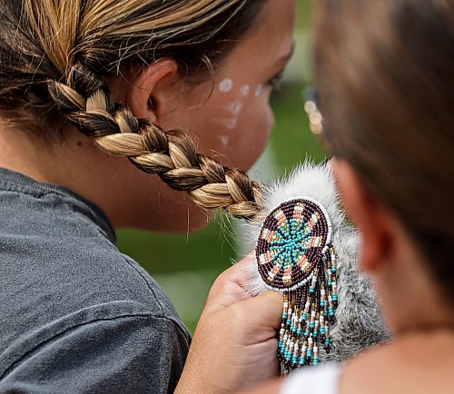 JOHN WOODS / FREE PRESS
Finishing touches are done to a braid as people prepare to participate in the grand entrance of the powwow at Anishinaabe Days Sunday, July 26, 2026.
reporter: standup