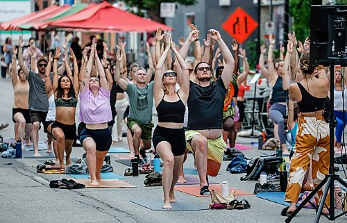 JOHN WOODS / FREE PRESS
Jessica from Rogue Vinyasa Yoga leads a session outside on a closed Corydon Avenue Sunday, July 26, 2026. The city is closing Corydon on multiple Sundays throughout the summer.

reporter: standup