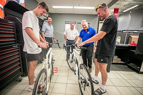 MIKAELA MACKENZIE / FREE PRESS
Thomas Clark (left) and Val Duquenne greet Canadian Tire folks Brad Elliott (left), Marc Gaudreau, and Chris Coenen with their new bikes on Monday, July 27, 2026. The two are biking across Canada to raise awareness for menճ mental health, and have just gotten new bikes through community support after having their original ones stolen during their stop in Winnipeg.
For Tiago story.
Free Press 2026