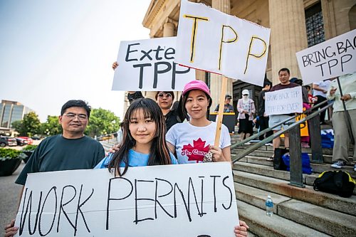 MIKAELA MACKENZIE / FREE PRESS
	
Adam Ning (left), Hannah Ning (centre, 12), Shang Zhang (right) and Qingjai Chu take part in a temporary foreign workers rally outside of the Manitoba Legislative Building on Tuesday, July 28, 2026.

For Carol story.
Free Press 2026