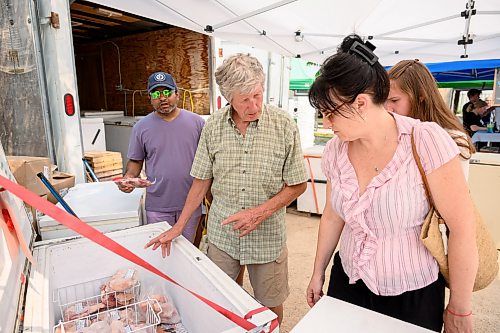 Mike Sudoma / Free Press
Jim Lintott of Lintott Farms helps out a group of customers at his booth at the St Norbert Farmers Market Saturday afternoon
July 25, 2026