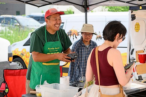 Mike Sudoma / Free Press
Tom Wang of Fertile Farms smiles after helping their final customers row the day Saturday at the St Norbert Farmers Market
July 25, 2026