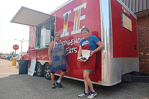 Indigenous Eats manager Christie Cook (left) and cook Roberta Baker take a short break to pose for a photo during a hot Tuesday afternoon. The Indigenous Eats food truck was stationed in front of the Victoria Inn on Tuesday with plenty of people supporting the mobile business. (Alex Lambert/The Brandon Sun)
