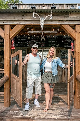BROOK JONES/FREE PRESS
Star Giesbrecht and her husband Lee Giesbrecht opened the Starlette's Burger Saloon in May 2025 after Lee made the dining patio to like an old-fashioned, western saloon from recovered barn wood. Pictured: Lee (left) and Star hold open the saloon doors on Saturday, July 26, 2026. The Starlette's Burger Saloon at 60122 Juno Rd., just north of Elma, Man.