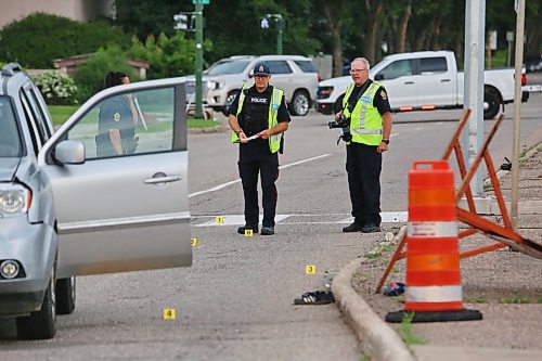 A Brandon police photographer works with investigators at the scene of a collision between an SUV and a 16-year-old girl at a crosswalk on Richmond Avenue, just west of 18th Street, on July 7. (Matt Goerzen/The Brandon Sun files)