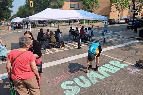 The Brandon Summer Market kicks off in the afternoon as crew puts extra touches on chalk signage. (Connor McDowell/The Brandon Sun)