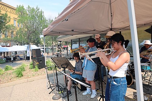 Awiitin, a band from Winnipeg, plays at the Brandon Downtown Summer Market on Wednesday afternoon. The band played renditions of “Love Never Felt So Good,” and “Superstition” during their show with a drum kit, a bass guitar, a saxophone, two trumpets and a guitar. (Connor McDowell/The Brandon Sun)