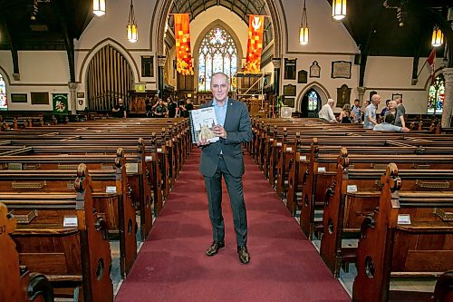 BROOK JONES/FREE PRESS
Holy Trinity Anglican Church and CentreVenture Development Corporation officially launch Phase II of the Holy Trinity Heritage Renewal Initiative, a major planning process that will help shape the future of one of Winnipeg's most significant heritage landmarks, on Wednesday, July 29, 2026. Pictured: Stephen Borys, who is the President & CEO of Civic Muse Inc. and building project manager of Holy Trinity Anglican Churh, holding the first volumn of the Building Assessment and Heritage Condition Report while standing in the nave at Holy Trinity Church in Winnipeg, Man.