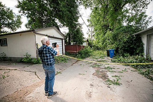 MIKAELA MACKENZIE / FREE PRESS
Neighbour Jake Falk checks out storm damage in the alley behind Stewart Street on Thursday, July 30, 2026.
For Chris story.
Free Press 2026
