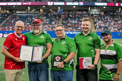 BROOK JONES/FREE PRESS
Rugby Canada honours the Winnipeg Wanderers Rugby Football Club's 100th anniversary during halftime of the match beween the Canadian men’s rugby union and Zimbabwe at Princess Auto Stadium in Winnipeg, Man., Saturday, July 18, 2026. The Wanderers were recognized with a celebratory plaque from Rugby Canada, the City of Winnipeg Community Service Award, and a book called It's a Try!: The History of Rugby in Canada written by Doug Sturrock. Pictured from left: Winnipeg Mayor Scott Gillingham, Wanderers President Brad Hirst, Wanderers Vice President Dan Fardoe, Wanderers Secretary Turner Green, and Wanderers men's team head coach Joey Potter.