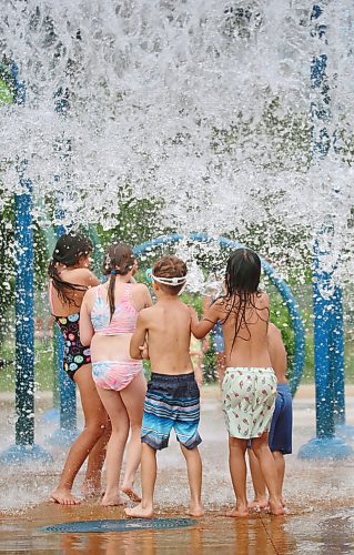 A crowd of kids brace themselves as a huge spray of water falls from the giant dump bucket at the Rideau Park Splash Pad on a pleasantly warm Friday afternoon. (Matt Goerzen/The Brandon Sun)