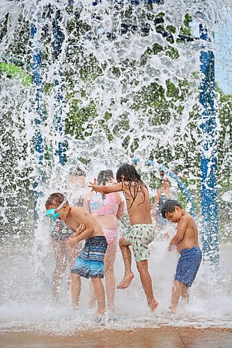 A crowd of kids get cool with a huge spray of water from the giant dump bucket at the Rideau Park Splash Pad on a pleasantly warm Friday afternoon. (Matt Goerzen/The Brandon Sun)