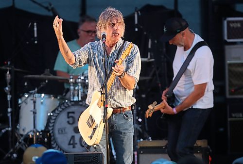 54-40 singer and guitarist Neil Osborne is briefly illuminated by a spotlight in front of bass guitarist Brad Merrit and drummer Matt Johnson during Rockin’ the Fields of Minnedosa on Sunday. (Perry Bergson/The Brandon Sun)