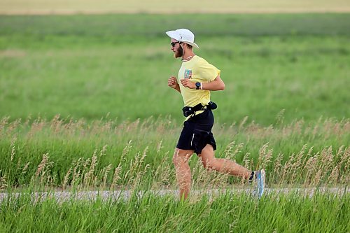 James Newman runs along a service road beside the Trans-Canada Highway west of Brandon on Tuesday as part of his goal to run across Canada in under 100 days. Newman, a 22-year-old from Oakville, Ont., is using his James Runs Canada run to raise money to support scholarships for youth through the Children’s Aid Foundation of Canada’s post-secondary education program. Organizers say he has raised more than $146,000 toward his $250,000 goal since he set out from St. John's, N.L., on May 18. (Tim Smith/The Brandon Sun)