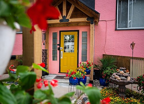 ROBERT LEE / FREE PRESS
Beryl Boney’s award-winning garden outside her home on St. Mary's Road in Winnipeg, on Wednesday, August 5, 2026. Boney, who grew up in Trinidad and Tobago, has spent 25 years transforming the front and back of her block with flowers and vegetables, including ceramic chickens that nod to her Caribbean roots.