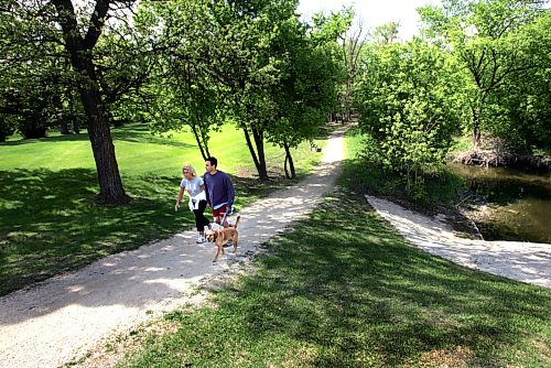 WAYNE GLOWACKI/WINNIPEG FREE PRESS Neighborhood.North Kildonan. Doug and Brigitte Pescitelli take Libby for a walk along the Bunn’s Creek trail . For Sharon Adams story May 15 2007