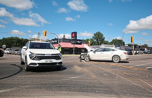 A Brandon Police officer directs traffic near one of two vehicles involved in a collision at the Park Avenue and 18th Street intersection on Friday during the noon hour. Airbags were deployed within the vehicle, though Brandon Police indicated later Friday afternoon that there were no known injuries as a result of the collision. (Matt Goerzen/The Brandon Sun)