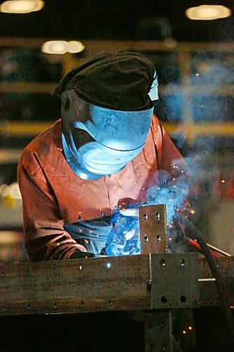 Heat from a welder illuminates an employee at Behlen Industries on Douglas Street in Brandon on Monday afternoon. Behlen is manufacturing and supplying the pre-engineered buildings for Bell Canada’s massive artificial intelligence data centre in Sherwood, Sask. (Matt Goerzen/The Brandon Sun)