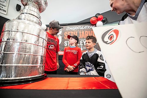 MIKAELA MACKENZIE / FREE PRESS
	
Seth Jarvis (left) poses for a photo with Linden Howard (10) and Ellis Howard (eight) and the Stanley Cup at the Tuxedo Community Centre on Monday, Aug. 10, 2026.

For Grace Penner story.
Free Press 2026
