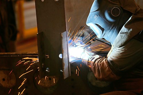 Heat from a welder illuminates an employee with Behlen Industries on Douglas Street on Monday afternoon. Behlen is manufacturing and supplying the pre-engineered buildings for Bell Canada’s massive 300 MW artificial intelligence data centre in Sherwood, Saskatchewan. As a result, the Brandon-based company has increased its production and invested in new equipment. (Matt Goerzen/The Brandon Sun)