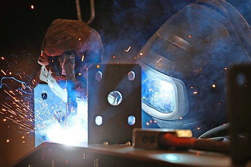 Heat from a welder illuminates an employee with Behlen Industries on Douglas Street on Monday afternoon. Behlen is manufacturing and supplying the pre-engineered buildings for Bell Canada’s massive 300 MW artificial intelligence data centre in Sherwood, Saskatchewan. As a result, the Brandon-based company has increased its production and invested in new equipment. (Matt Goerzen/The Brandon Sun)