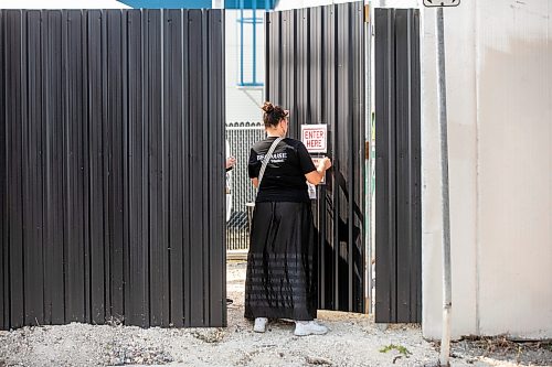 MIKAELA MACKENZIE / FREE PRESS
	
Charlene Hallett, with the Aboriginal Health and Wellness Centre of Winnipeg, tapes up a welcome sign onto the entrance of the supervised consumption site at 366 Higgins on Tuesday, Aug. 11, 2026.

For Malak story.
Free Press 2026