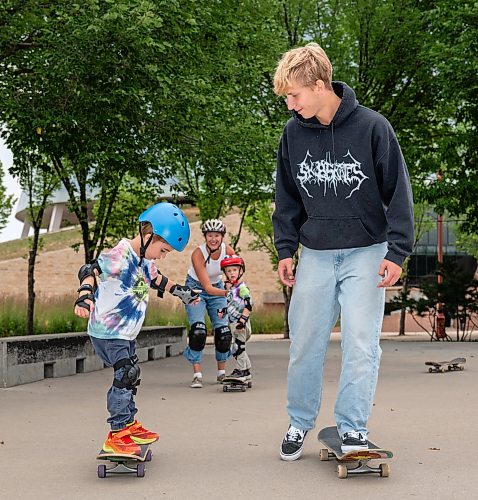 ROBERT LEE / FREE PRESS
First-time skateboarder Bodhi Case (left), 5, balances with the guidance of skateboarding instructor Quade Smeall while his mother, Sandra and brother Koa, 3, cheer from behind at the skate park at The Forks in Winnipeg on Tuesday, August 11, 2026.