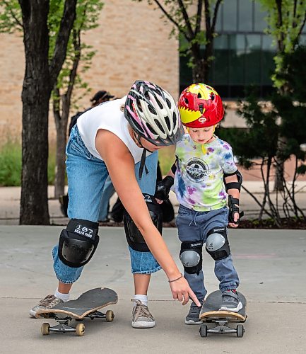 ROBERT LEE / FREE PRESS
Koa (right), 3, is helped onto his skateboard by his mother, Sandra Case at the skate park at The Forks in Winnipeg on Tuesday, August 11, 2026.