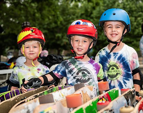 ROBERT LEE / FREE PRESS
Koa (left), 3, Kai, 3, and Bodhi, 5, choose their skateboards in anticipation of their first skateboarding lesson at the skate park at The Forks in Winnipeg on Tuesday, August 11, 2026.